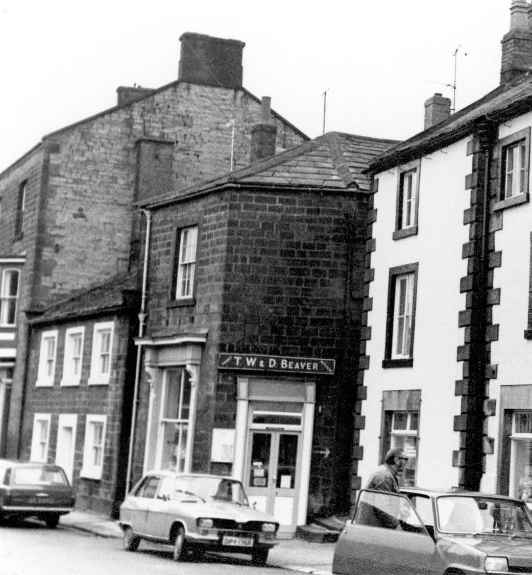 The original Beaver family butcher shop on Silver Street, Masham, the fascia reading T. W. and D. Beaver, with 1970s cars parked outside