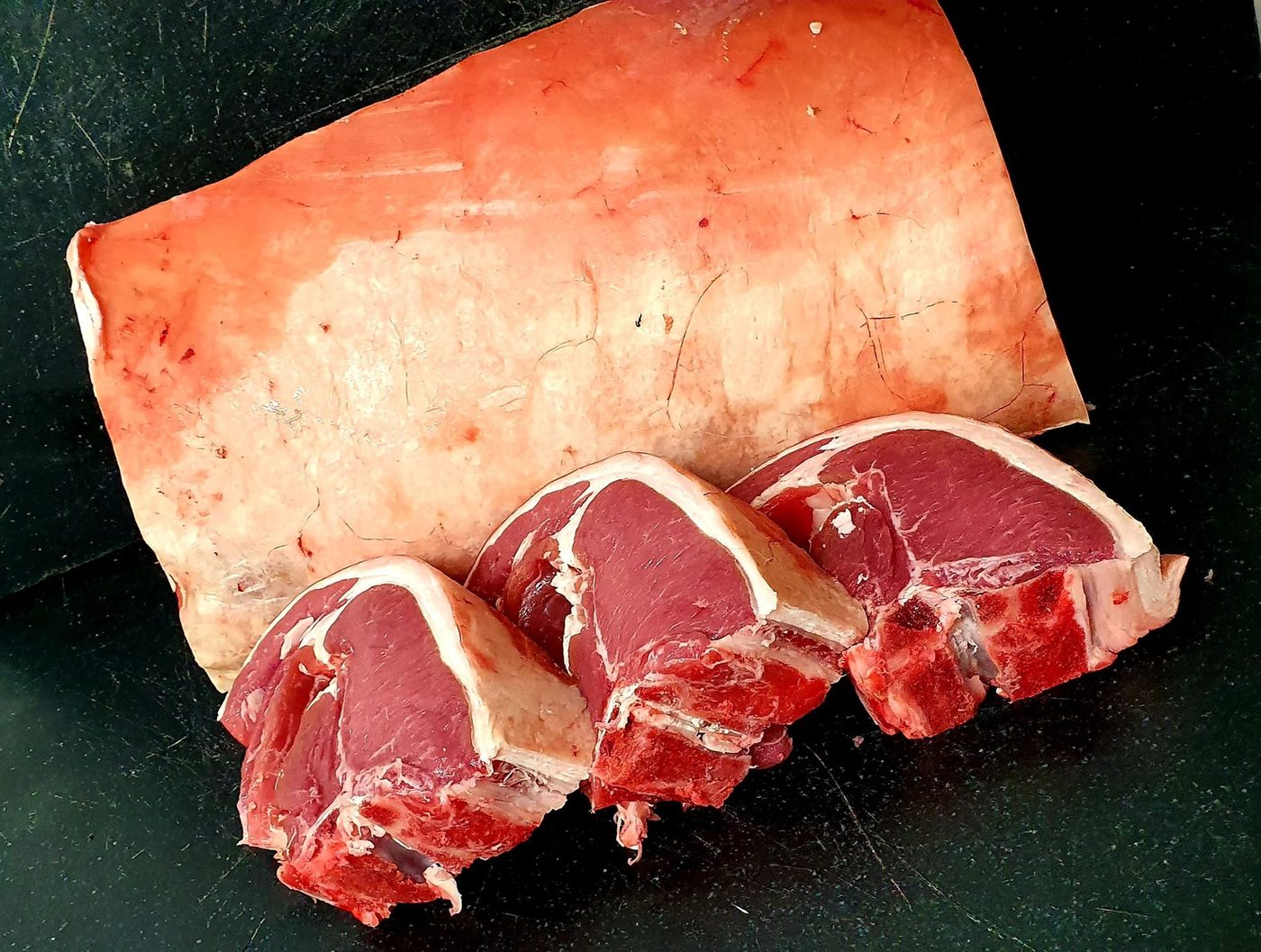 Lamb chops cut and laid out on the black slate counter at Beavers Butchers
