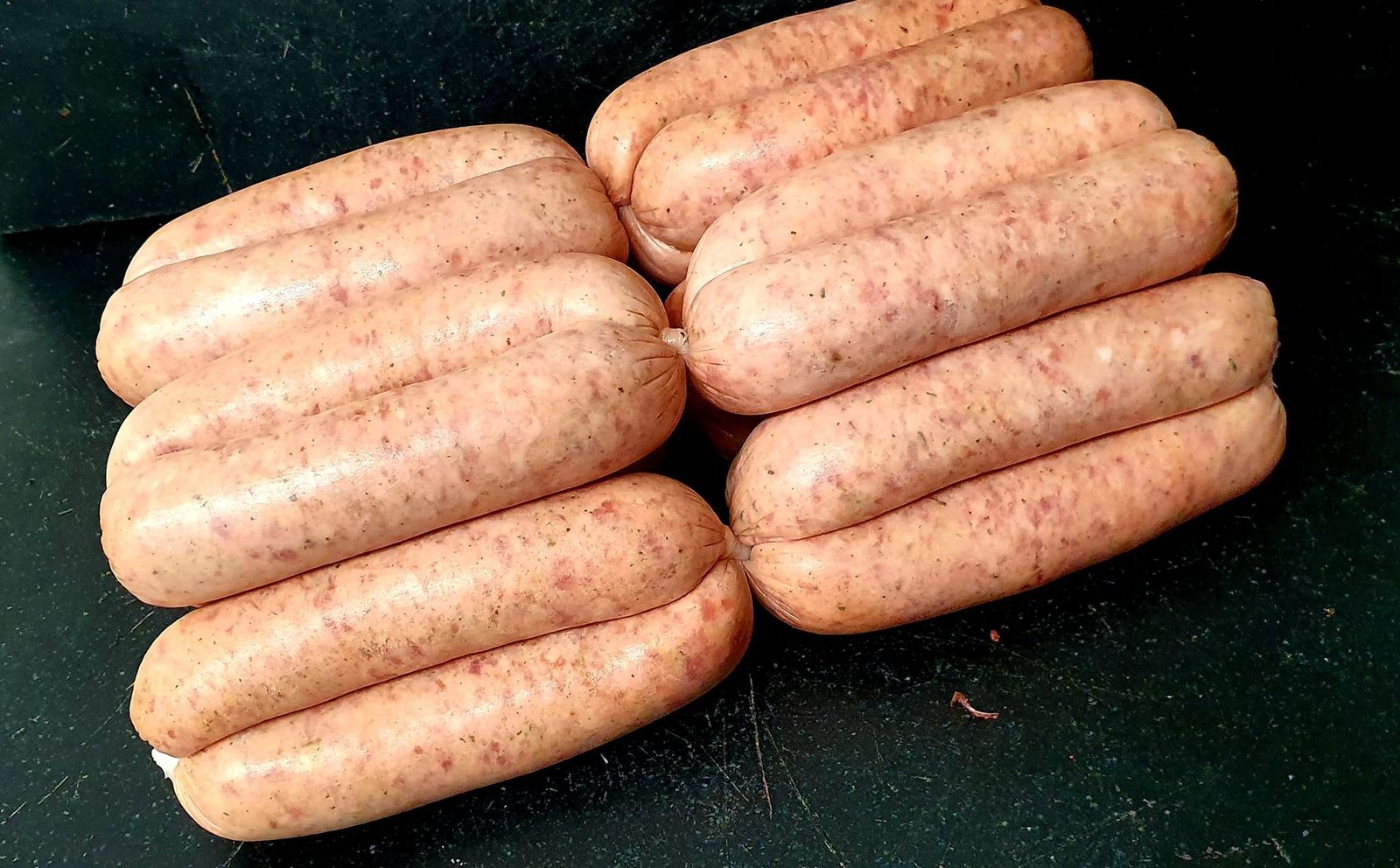 Fresh handmade sausages stacked on the black slate counter at Beavers Butchers, Masham